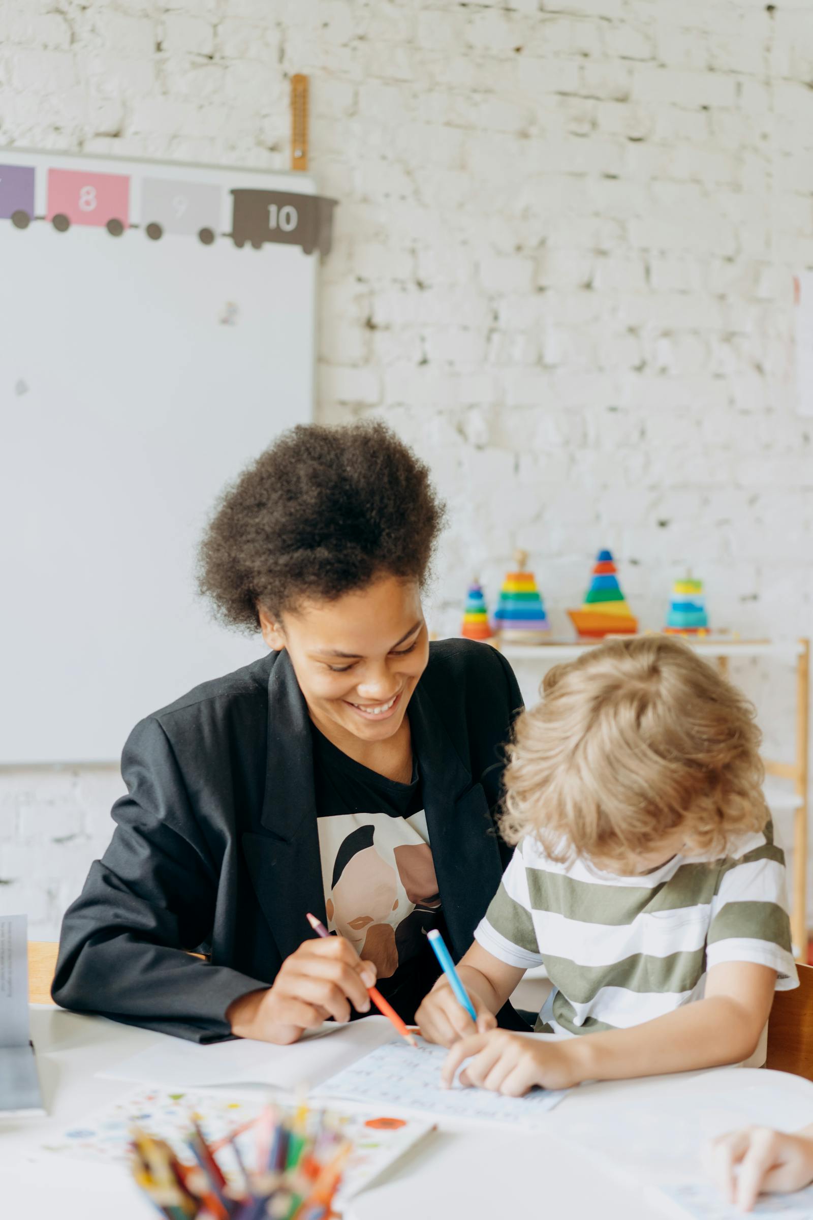Teacher guiding a young child through writing practice